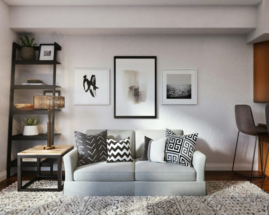 salon chic avec canapé gris, étagères noires et tableaux encadrés minimalistes