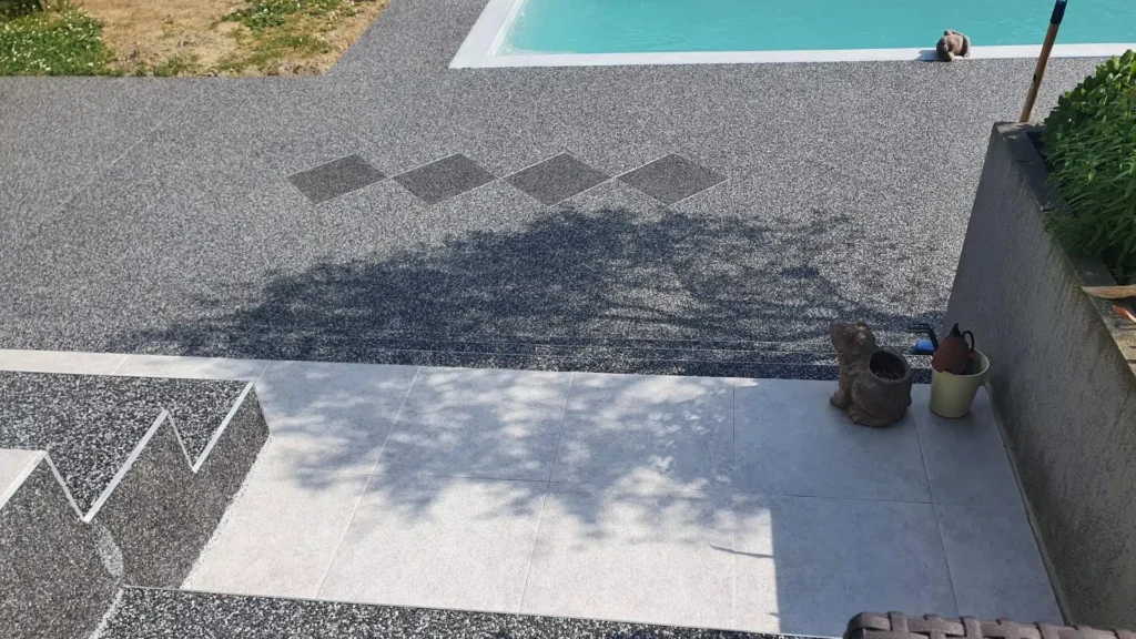 moquette de pierre grise autour d'une piscine avec terrasse carrelée