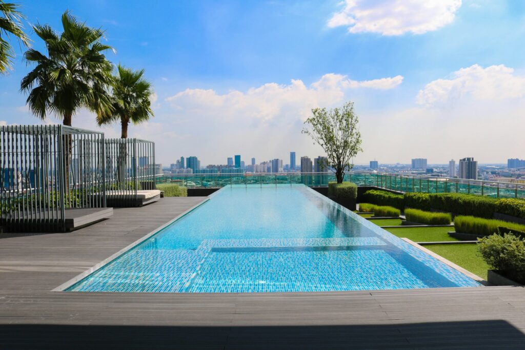 piscine moderne avec débordement infini dominant une skyline urbaine sous ciel bleu