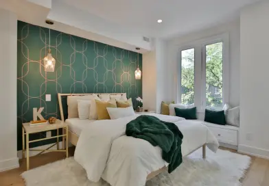 a bedroom with a green wall and a white bed