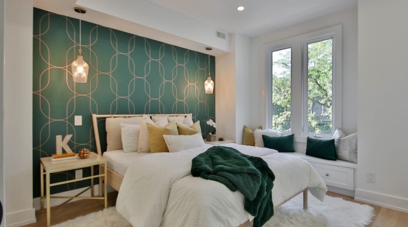a bedroom with a green wall and a white bed